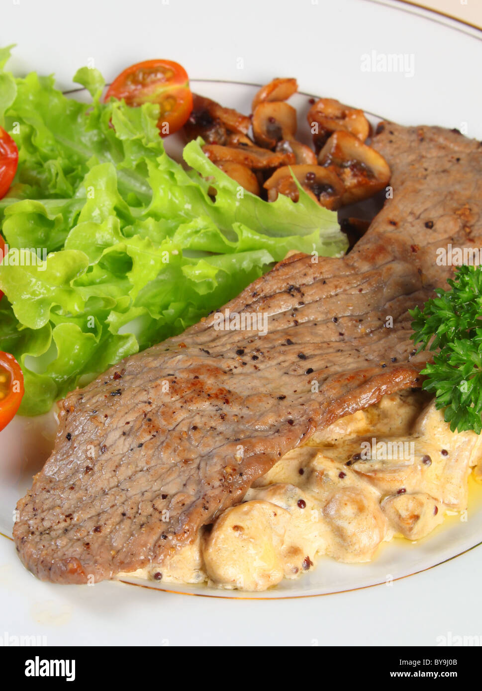 veal escalope on a bed of mushrooms in a cream and garlic sauce, served