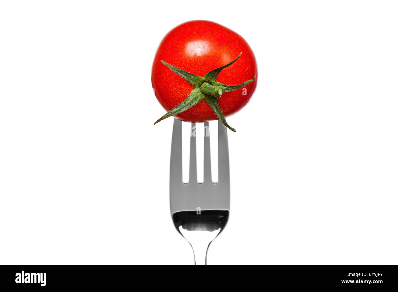 Photo of a tomato on a fork isolated on a white background, part of a series. Stock Photo