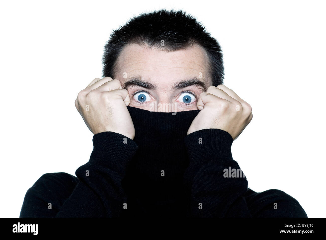 one caucasian shy man surprised anonymous hiding behind his pull over expressive portrait on studio isolated white background Stock Photo