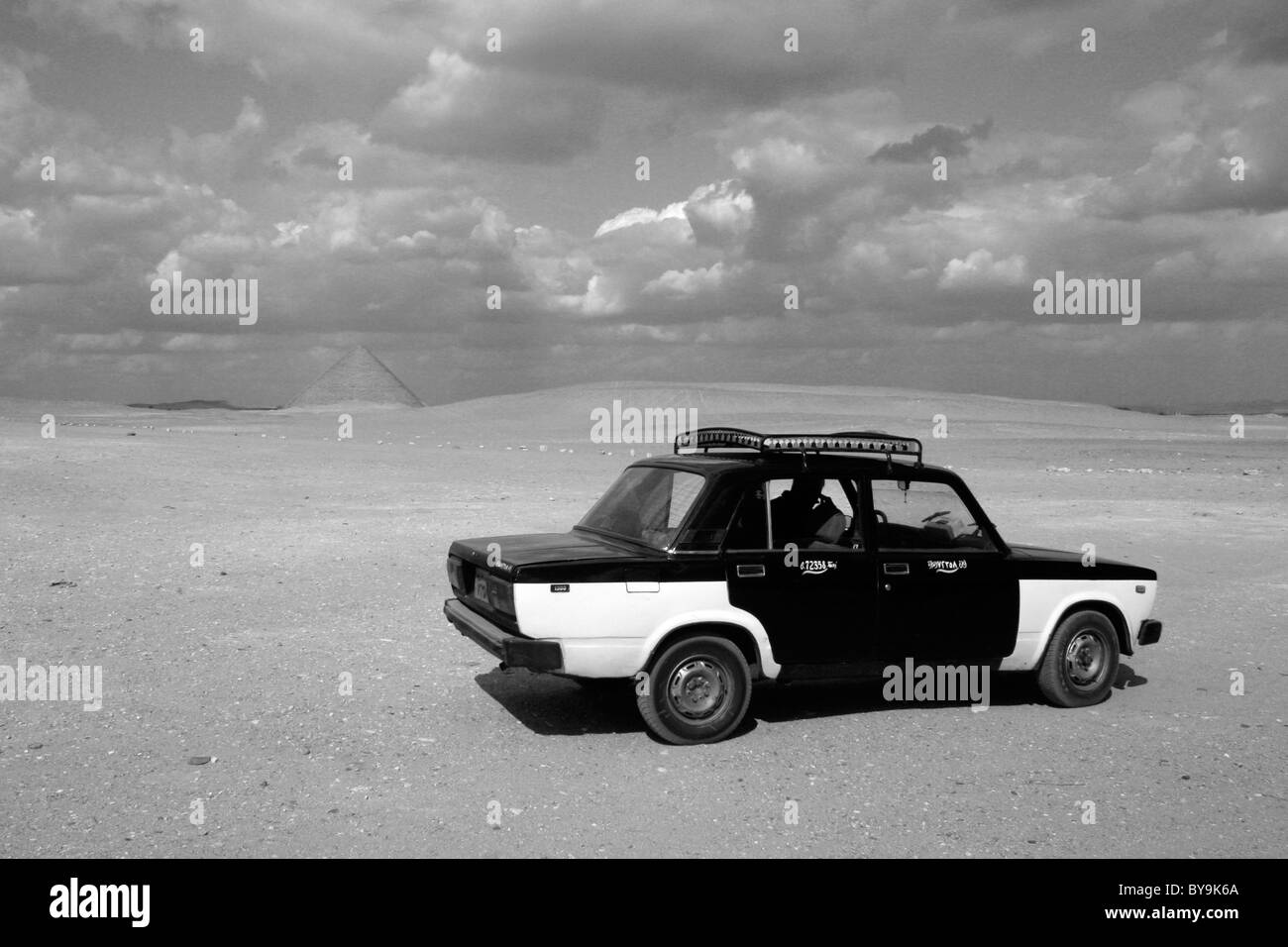 A taxi waiting in the desert with the Red Pyramid in the background near Cairo Stock Photo
