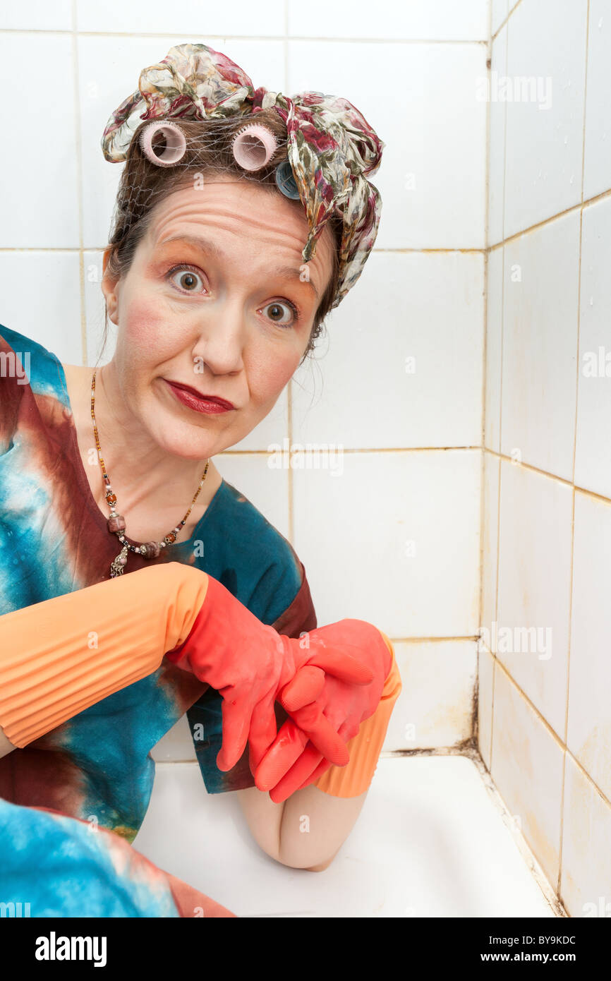 funny woman cleaner in dirty shower Stock Photo