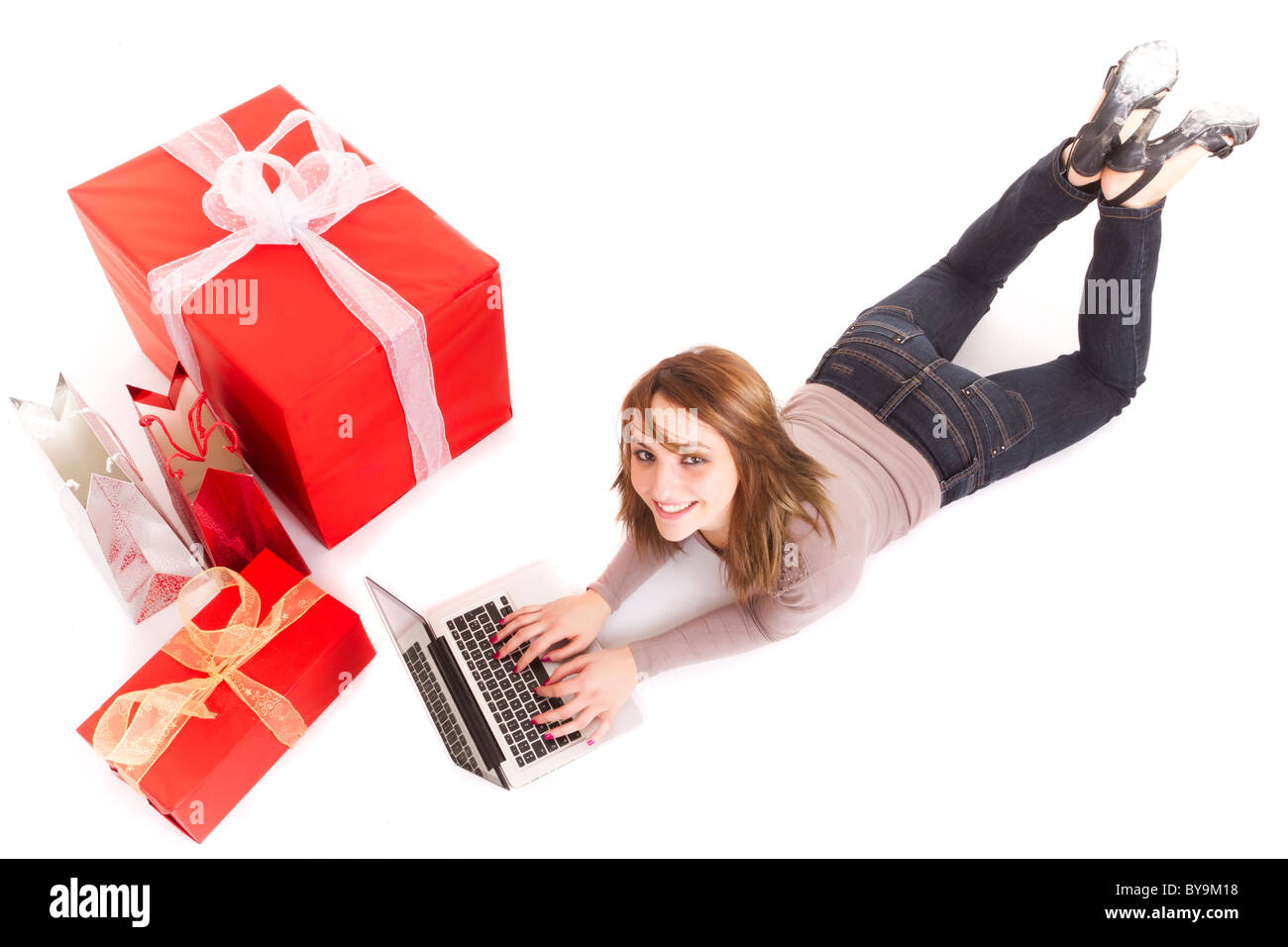 girl lying on floor buying presents online with laptop Stock Photo