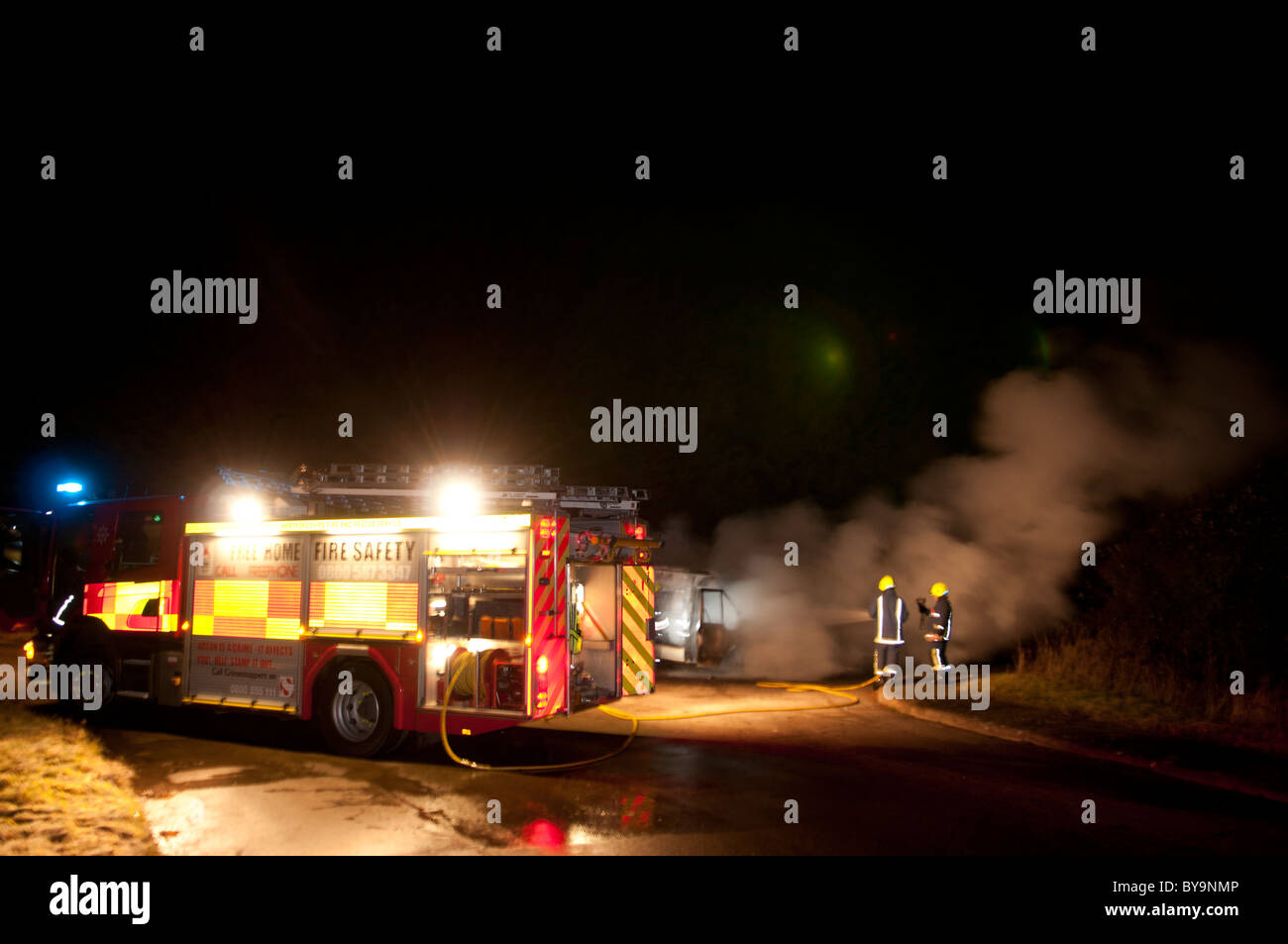 Fire Pump Ladder at a burning car at night Stock Photo