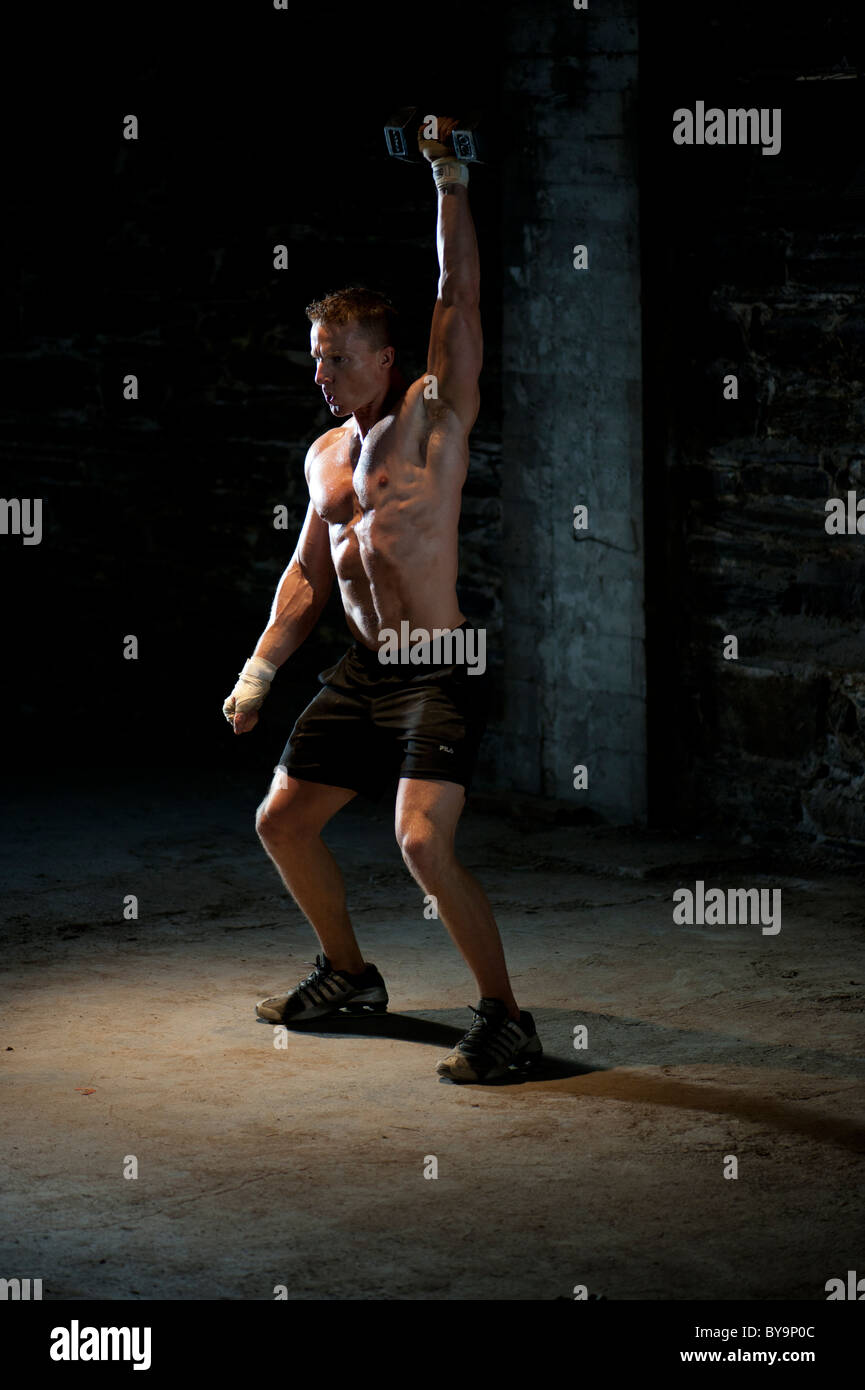 A male in incredible shape strengthening with weight training Stock