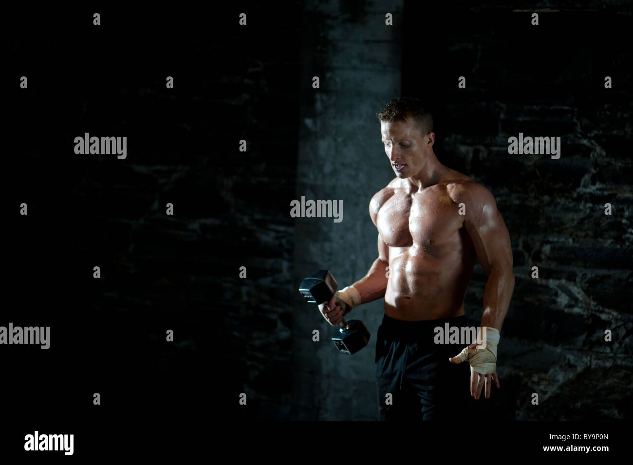 A male in incredible shape strengthening with weight training Stock