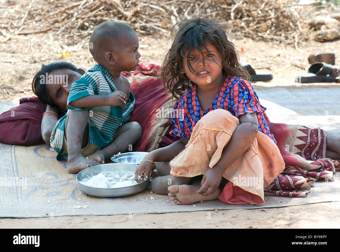 Poor lower caste Indian mother and children eating rice. Andhra Pradesh, India Stock Photo