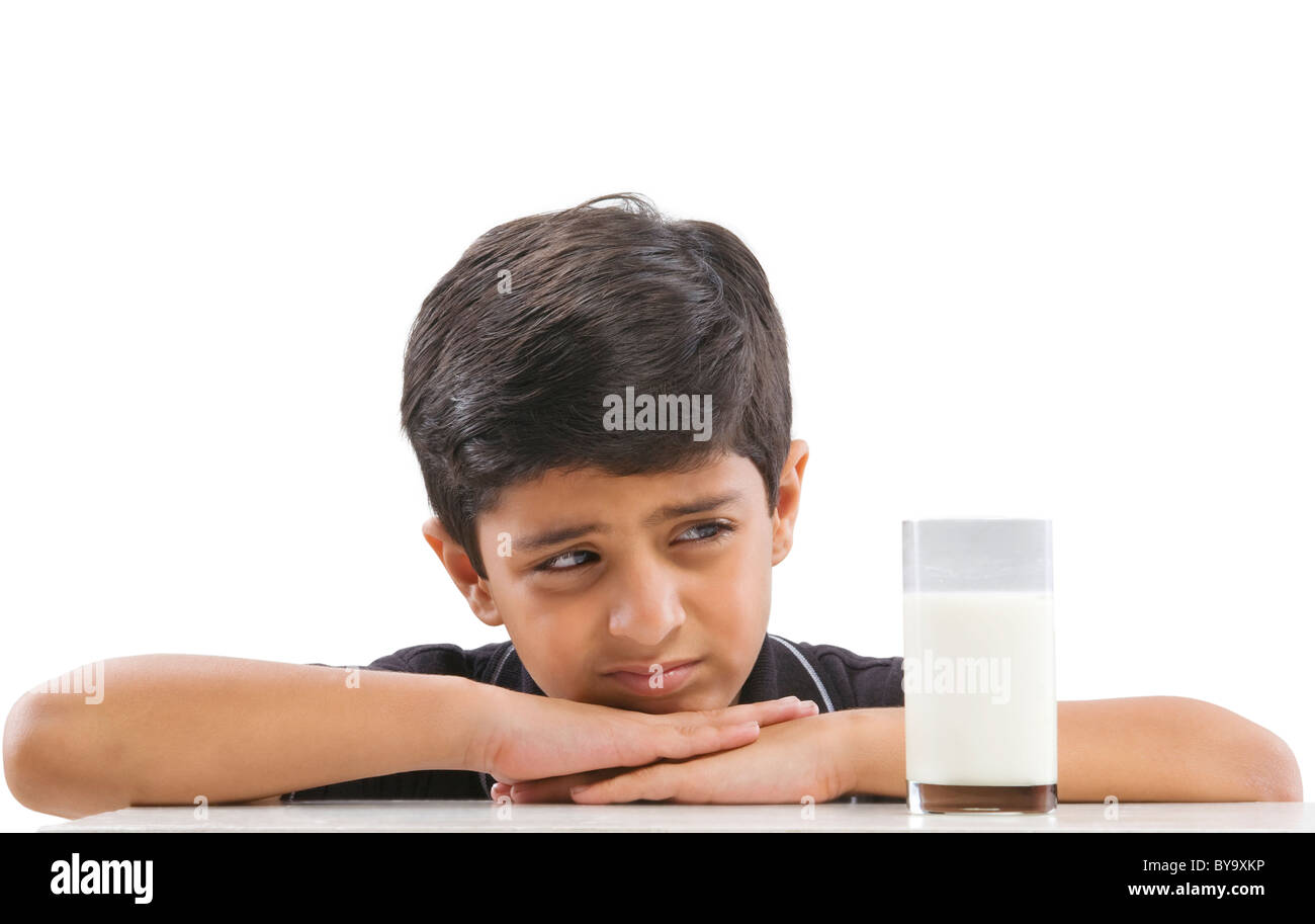 Young boy looking at a glass of milk Stock Photo