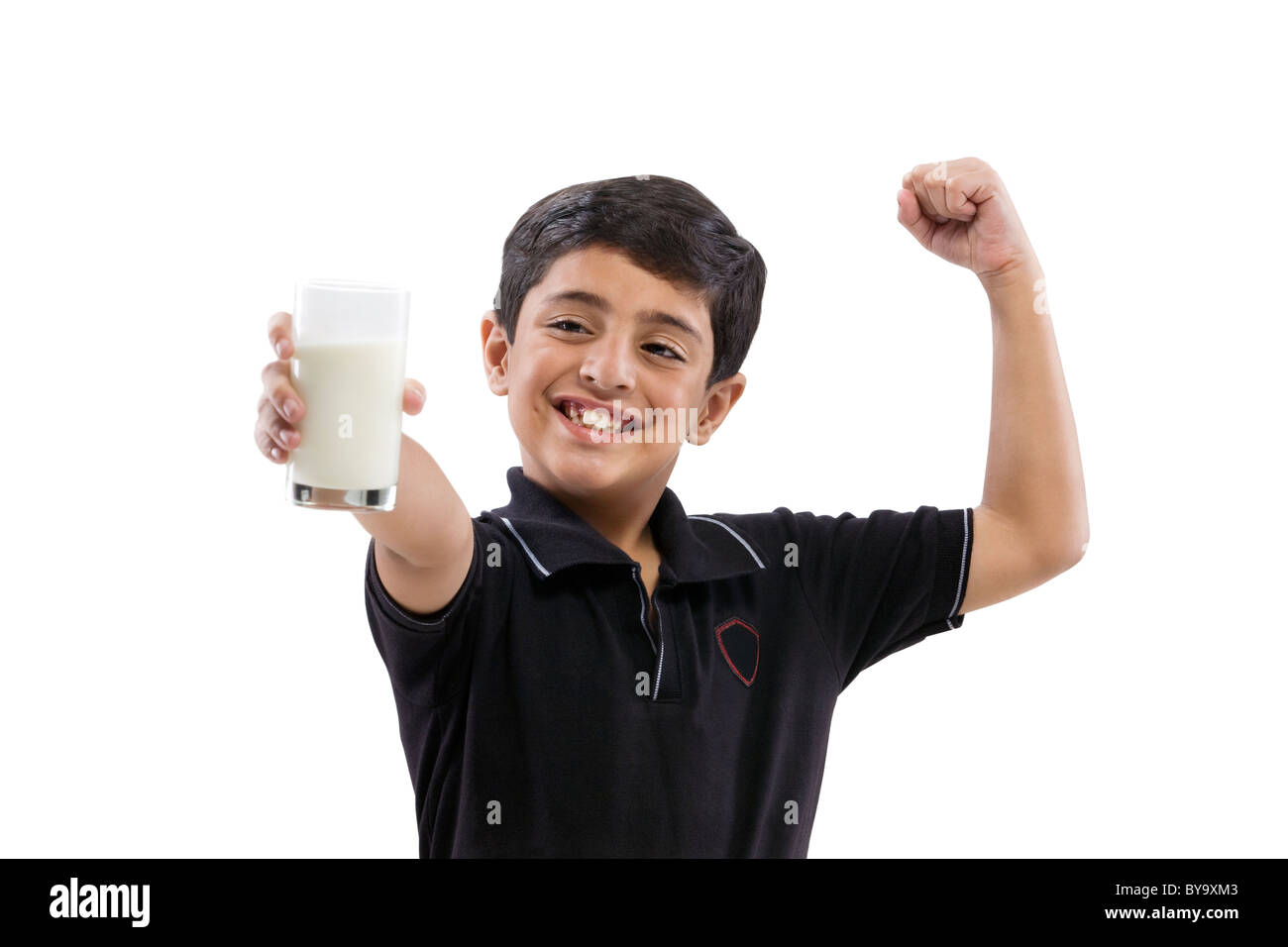 Young boy flexing his arm while holding a glass of milk Stock Photo