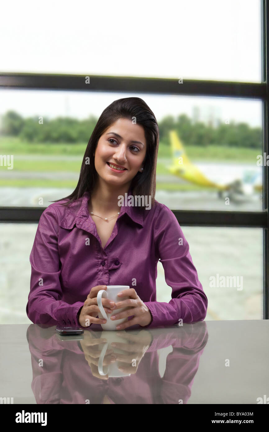 Woman sitting with a cup of coffee Stock Photo - Alamy
