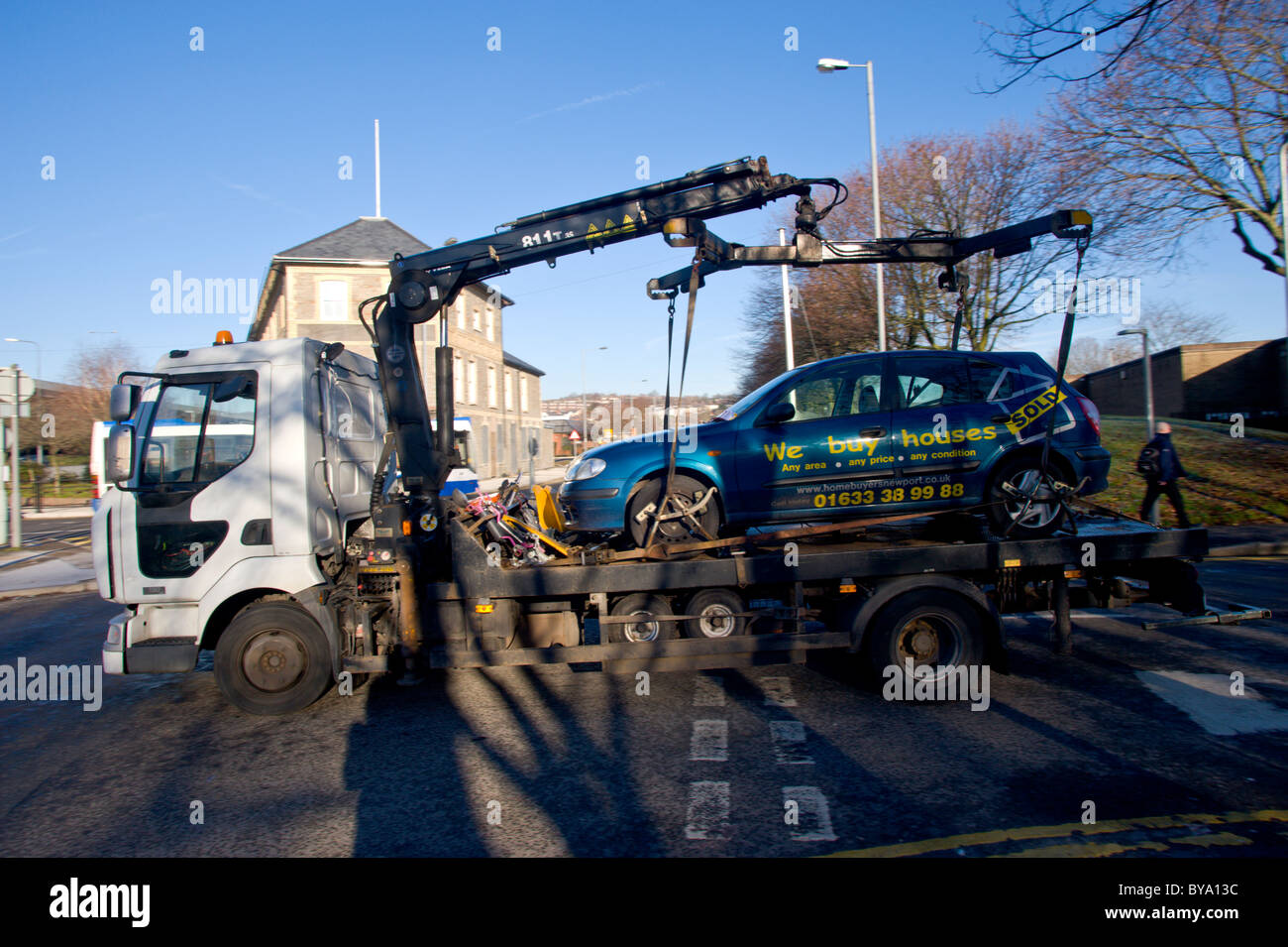 DVLA clamping unit removing cars on low loader from a residential area