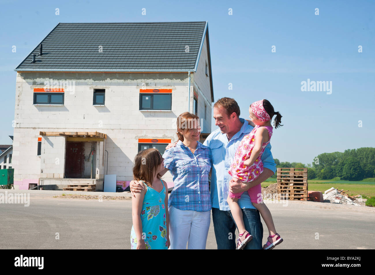 Family standing in front of their new home Stock Photo - Alamy