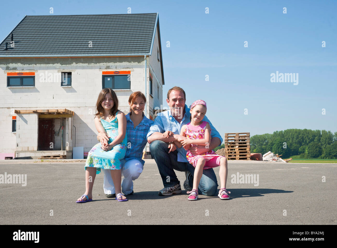 Family in front of their new home Stock Photo - Alamy