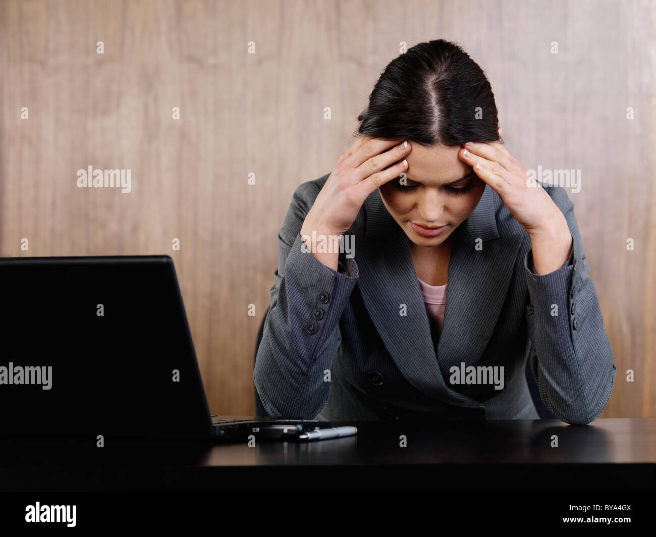 Business woman head in hands in office Stock Photo