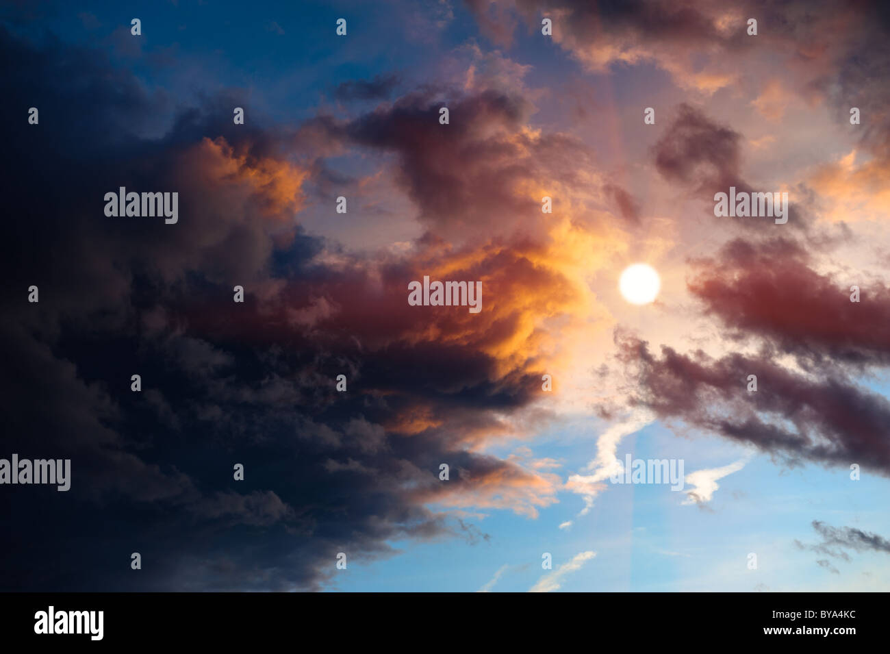 Dramatic sunset clouds surrounding sun. Stock Photo