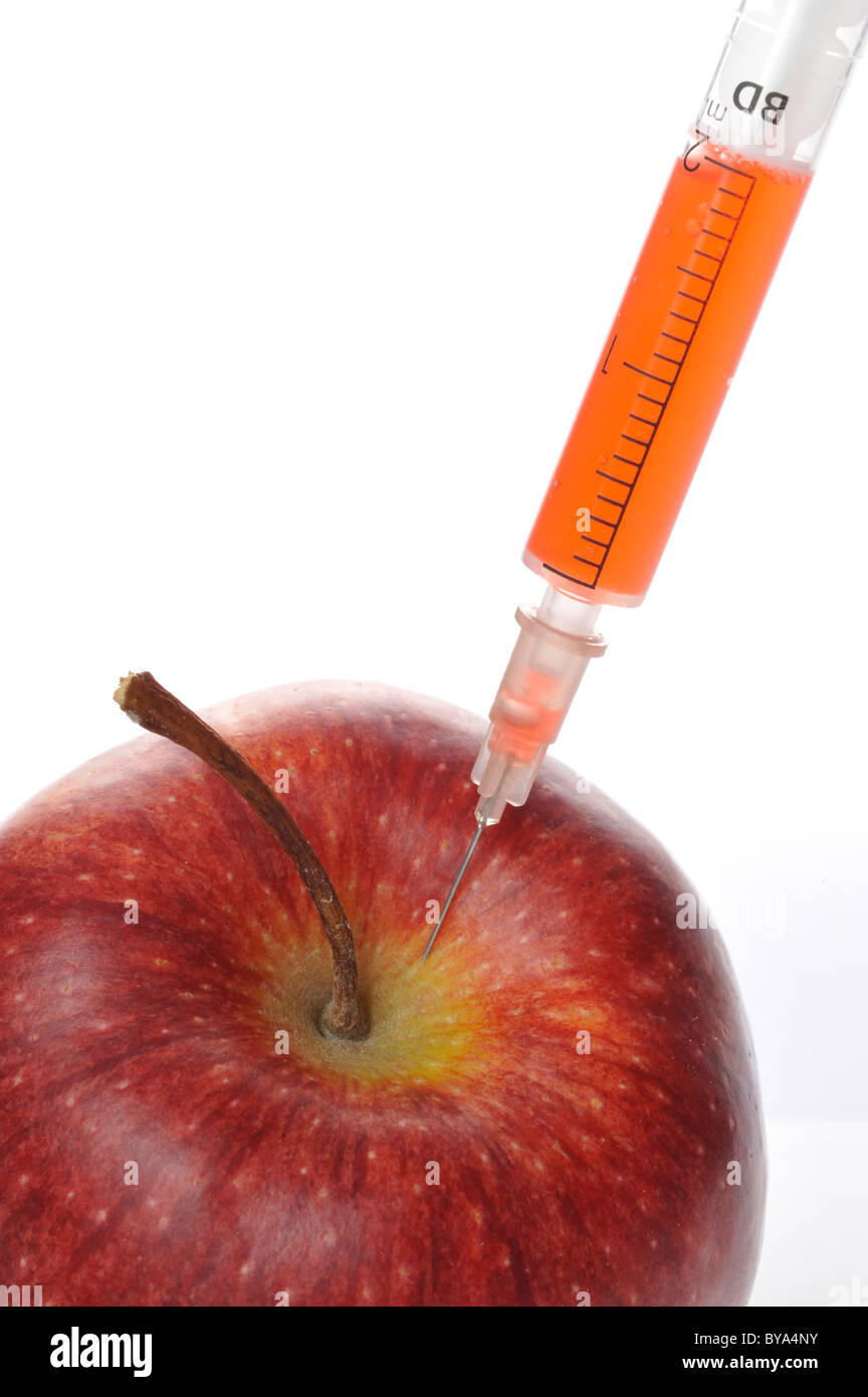 Syringe sticking in an apple, symbolic image for GM, genetically modified, food Stock Photo