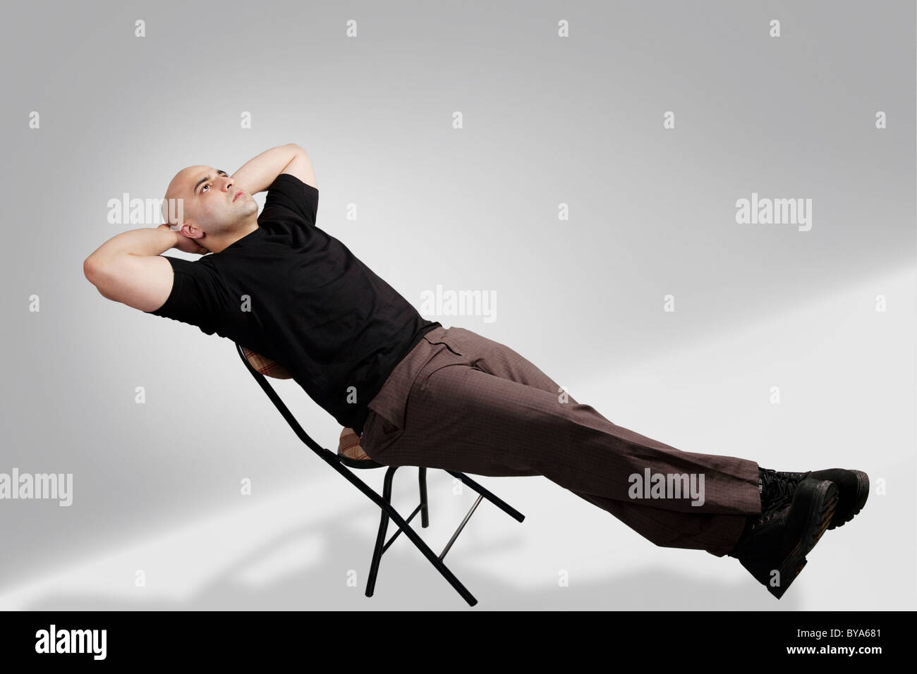 Man sitting on chair behind hi-res stock photography and images - Alamy