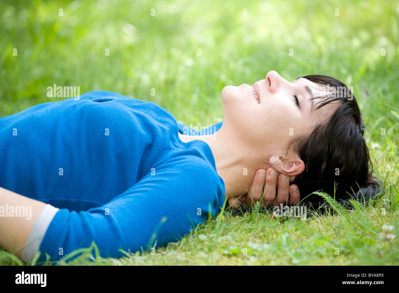 attractive woman relaxing on grass in park Stock Photo - Alamy