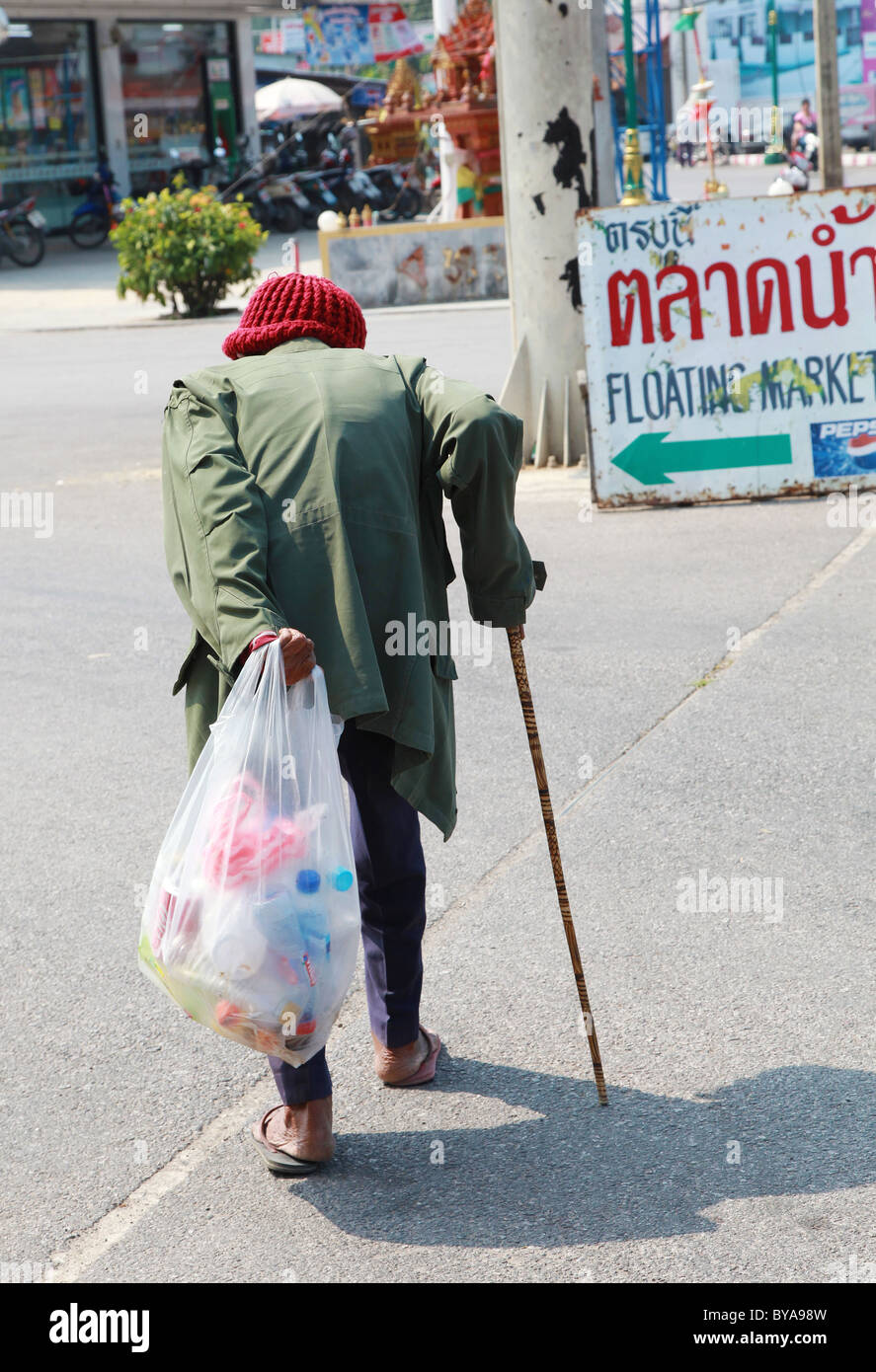 Back view of an elderly local man walking with cane, Thailand Stock Photo