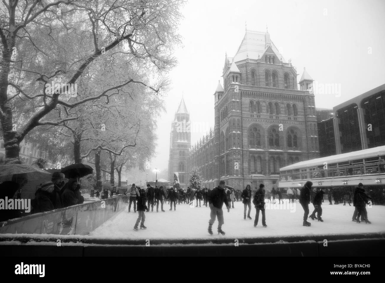 Ice skating at a snowbound Natural HIstory Museum ice rink, South Kensington, London, UK Stock Photo