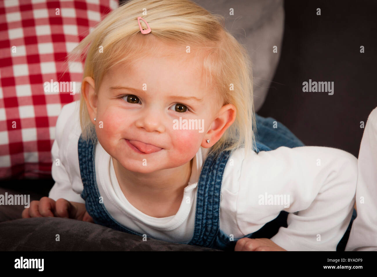 Girls, 1.5 years, cheekily sticking her tongue out Stock Photo