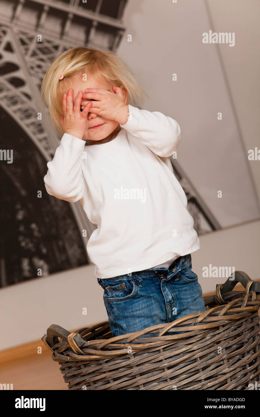 Girls, 1.5 years, playing hide and seek Stock Photo