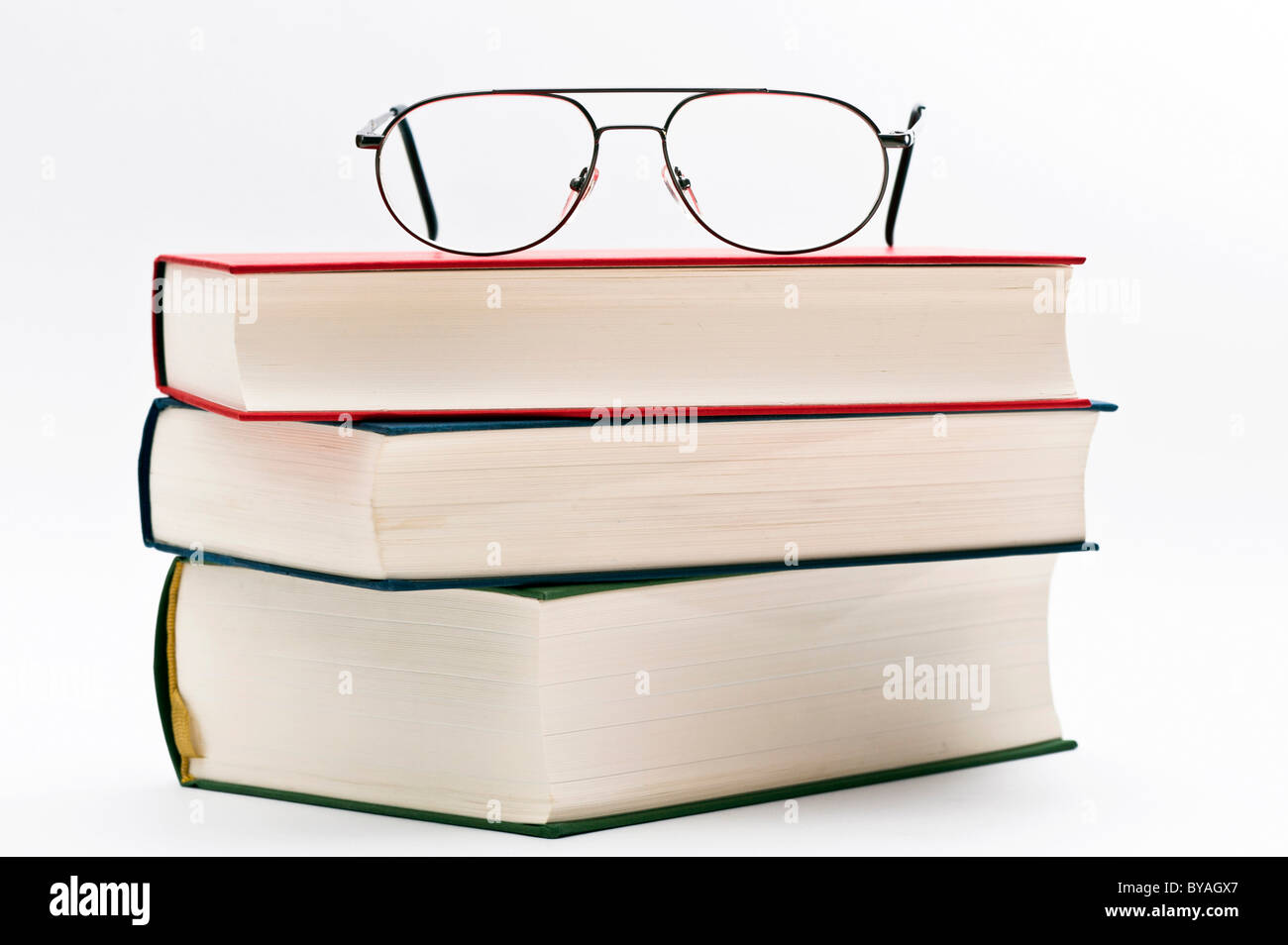 Reading glasses lying on a pile of books Stock Photo