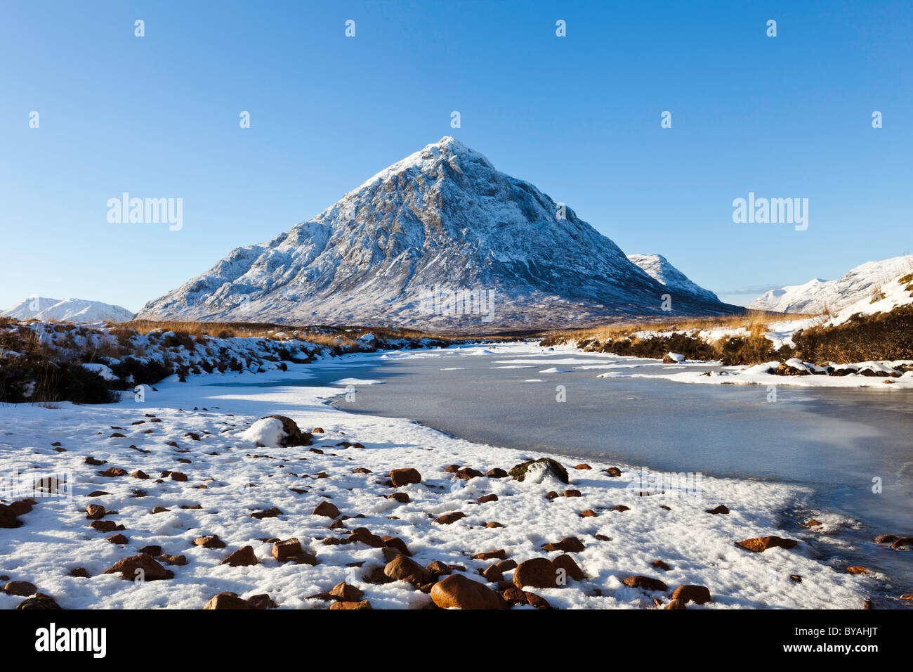 Landscape of Buachaille Etive Mor in the picturesque pass of Glencoe with the river etive frozen in the foreground Stock Photo