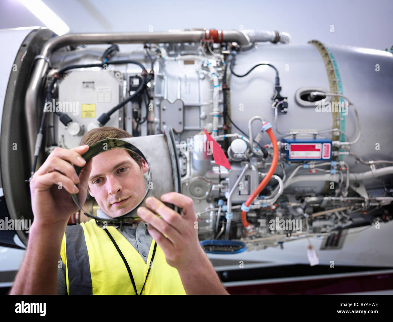 Engineer inspecting part of jet engine Stock Photo