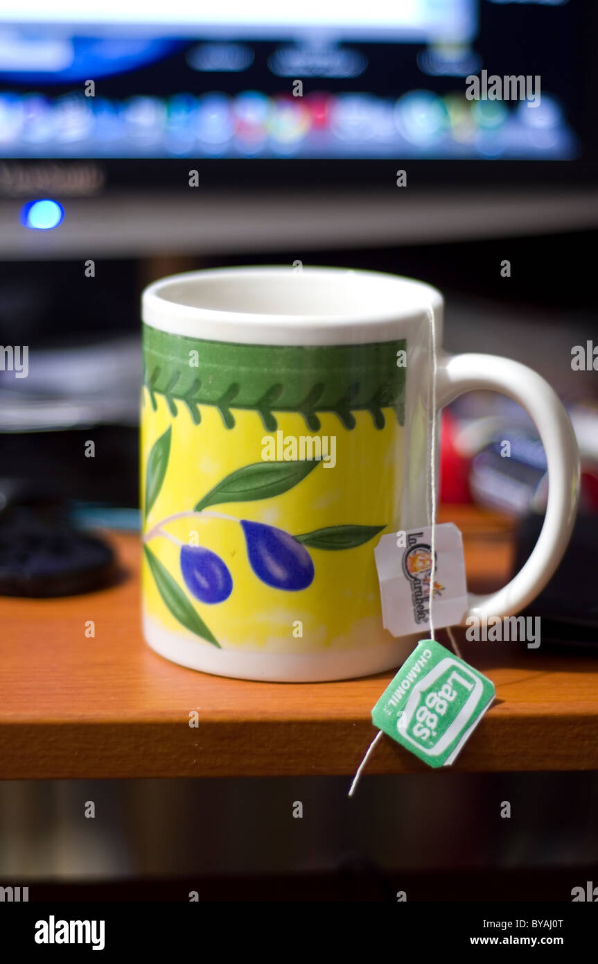 Photo of a cup of tea in front of a computer monitor Stock Photo - Alamy