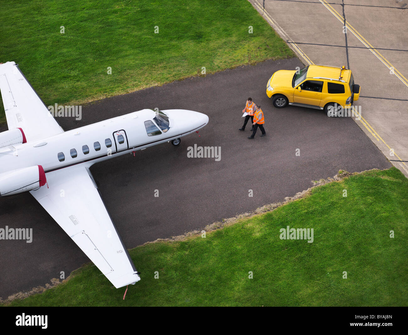Engineers with jet aircraft on runway Stock Photo