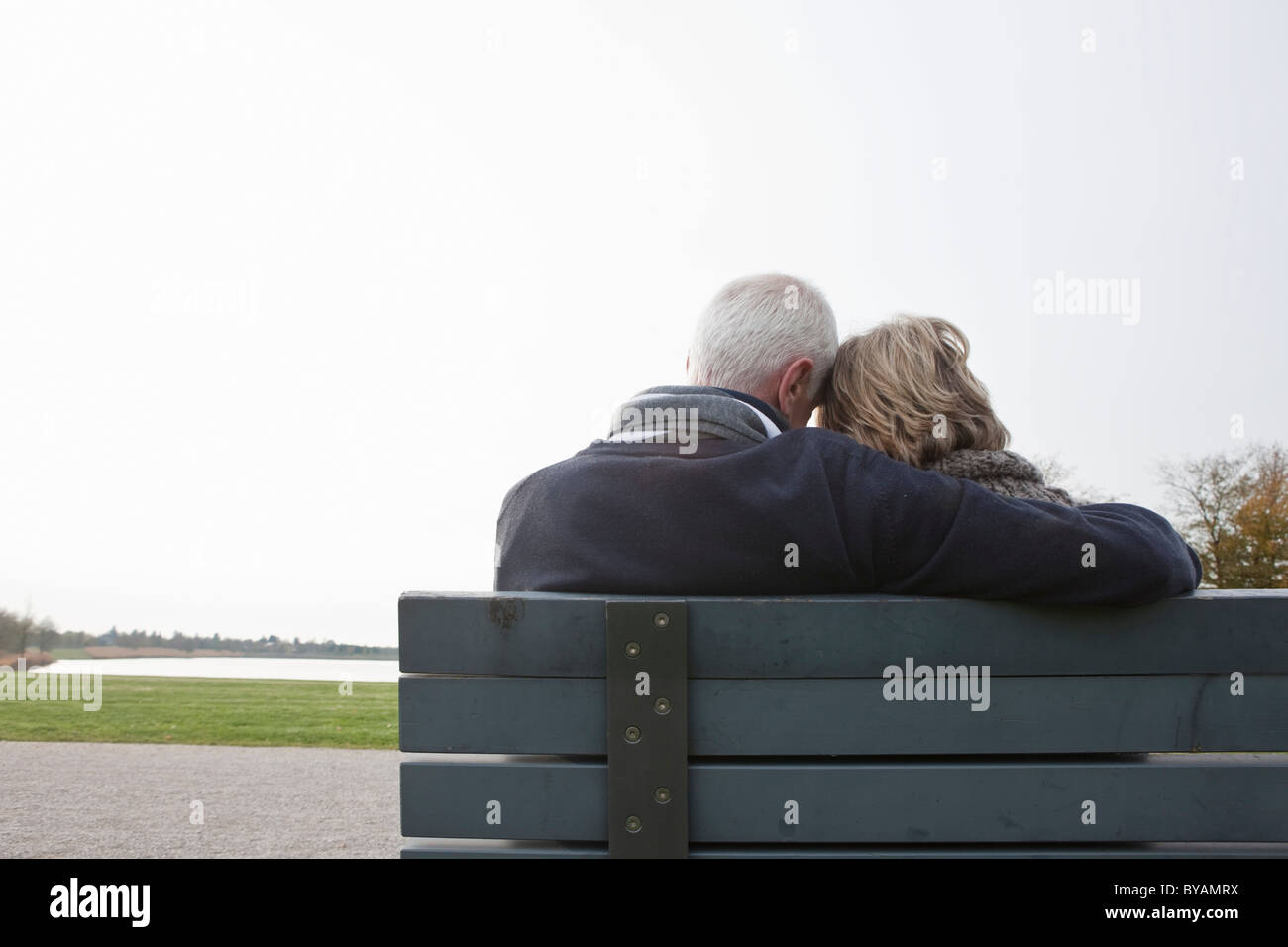Senior couple sitting on bench in park Stock Photo - Alamy