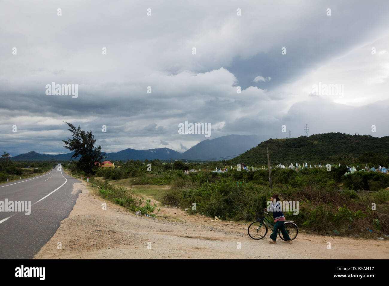 Woman holding her hat during a cyclone north of Danang along Hwy 1 in Vietnam Stock Photo