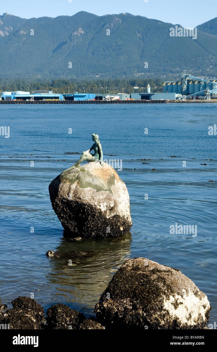 Girl in a wetsuit or mermaid on a rock in Stanley Park, Vancouver