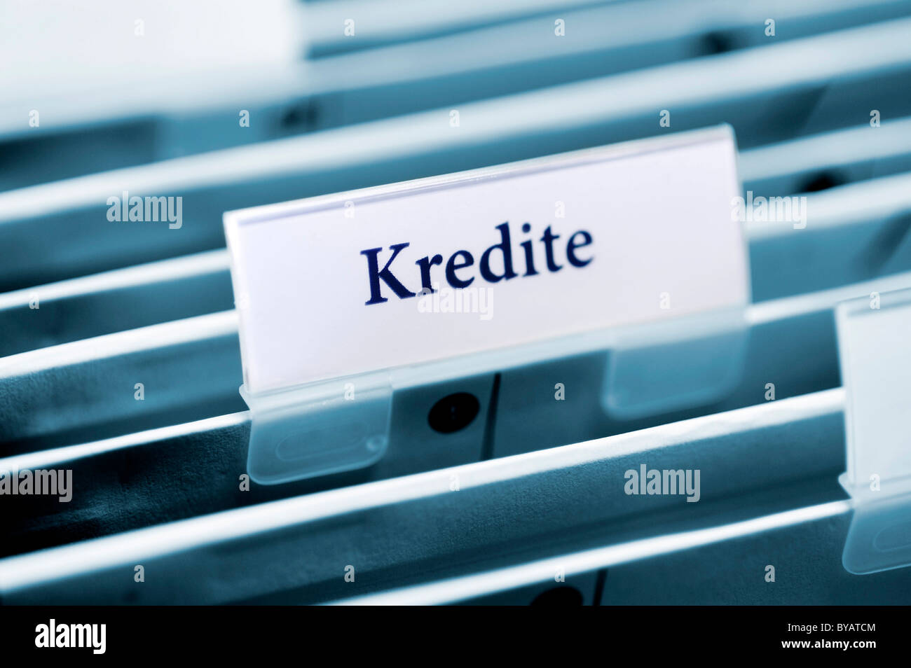 Rider on a hanging folder labeled Kredite or loans Stock Photo