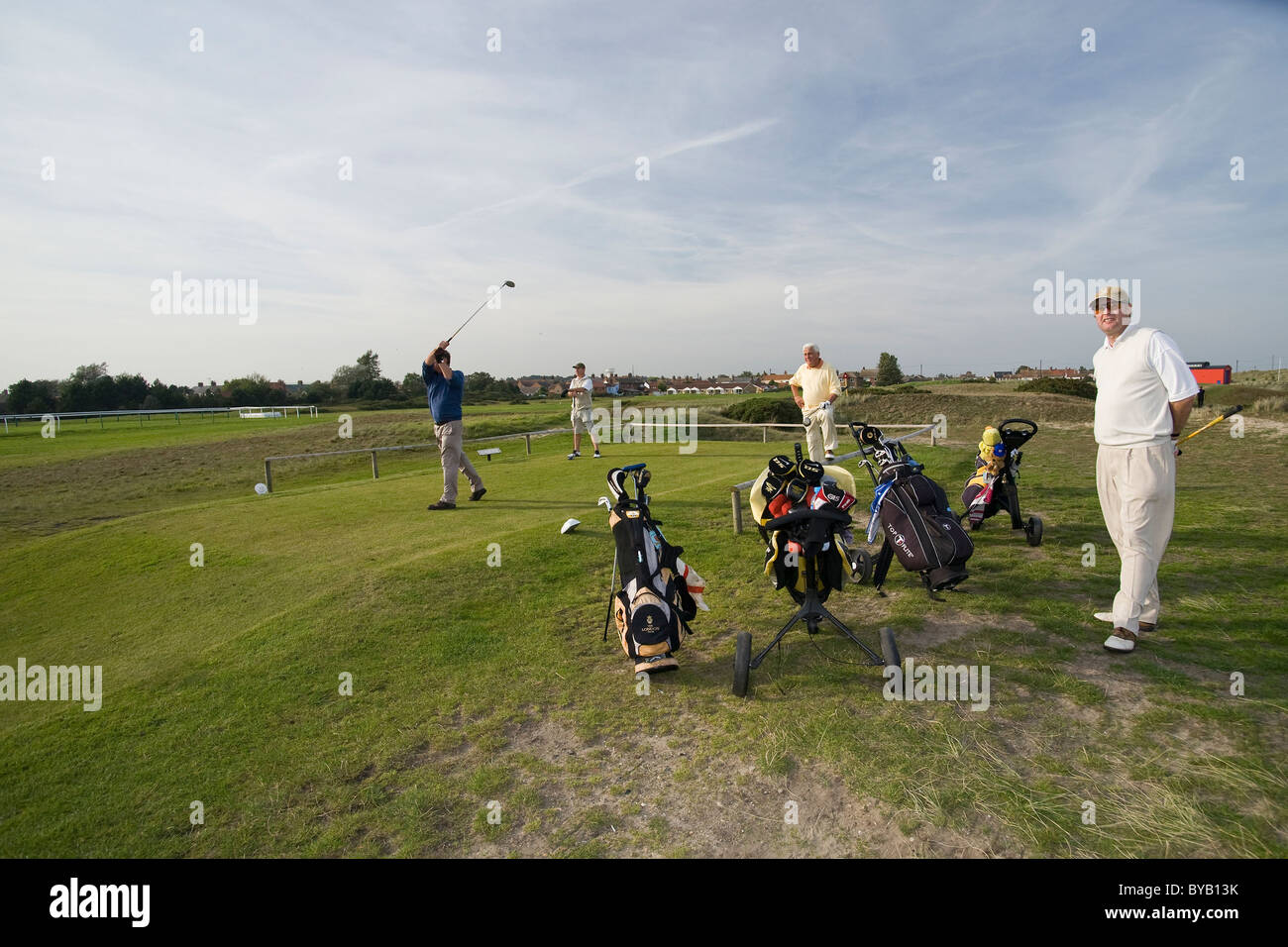 Golfers and their caddies on Caister golf course Stock Photo
