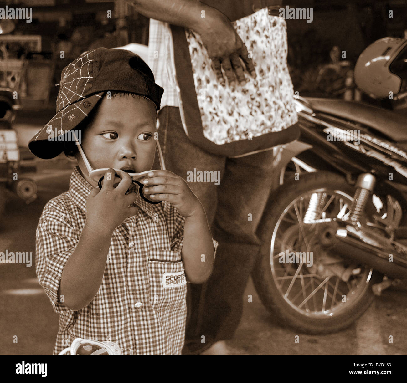 Sepia-toned photograph of a contemplative young Thai boy Stock Photo