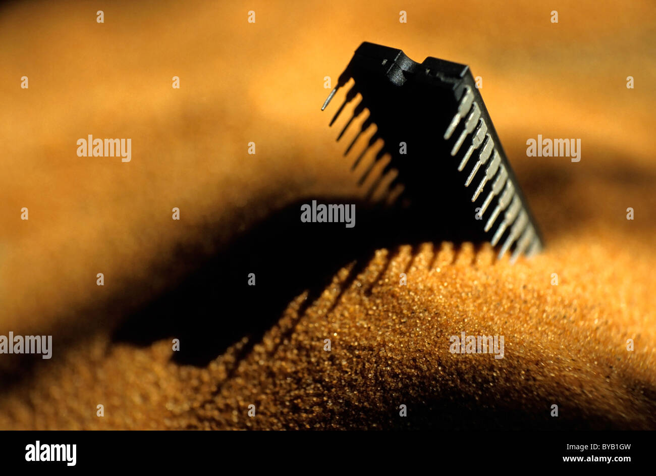 Computer chip halfburied in sand Stock Photo Alamy