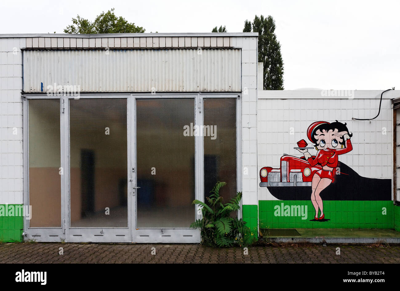 Abandoned car repair shop with a drive-in restaurant, advertising character painted on the wall, Krefeld, North Rhine-Westphalia Stock Photo