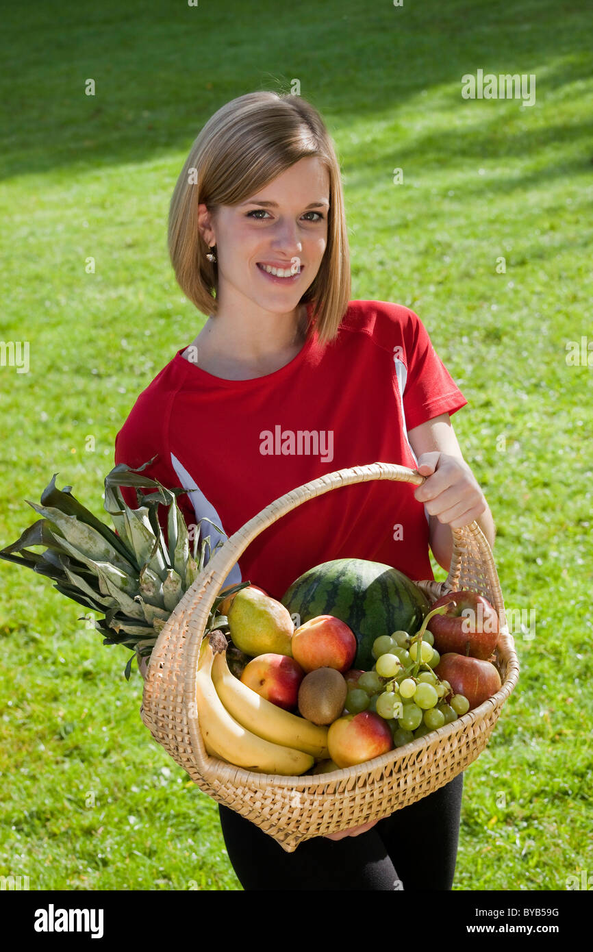 Young woman holding a fruit basket Stock Photo - Alamy