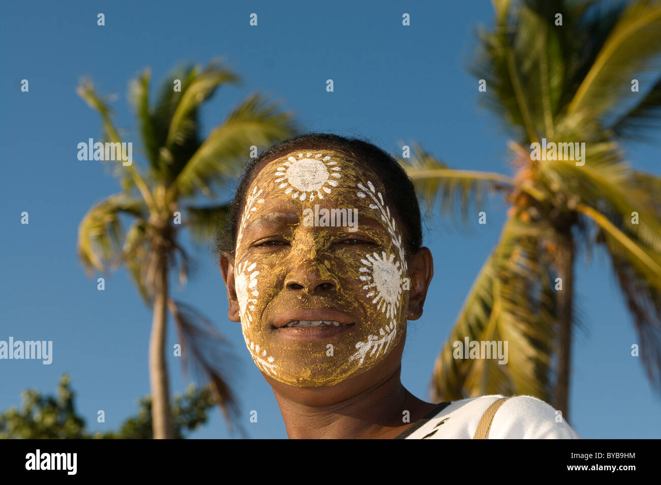 Portrait of smiling, dark-skinned woman with facial painting, Nosy Be, Madagascar, Africa Stock Photo