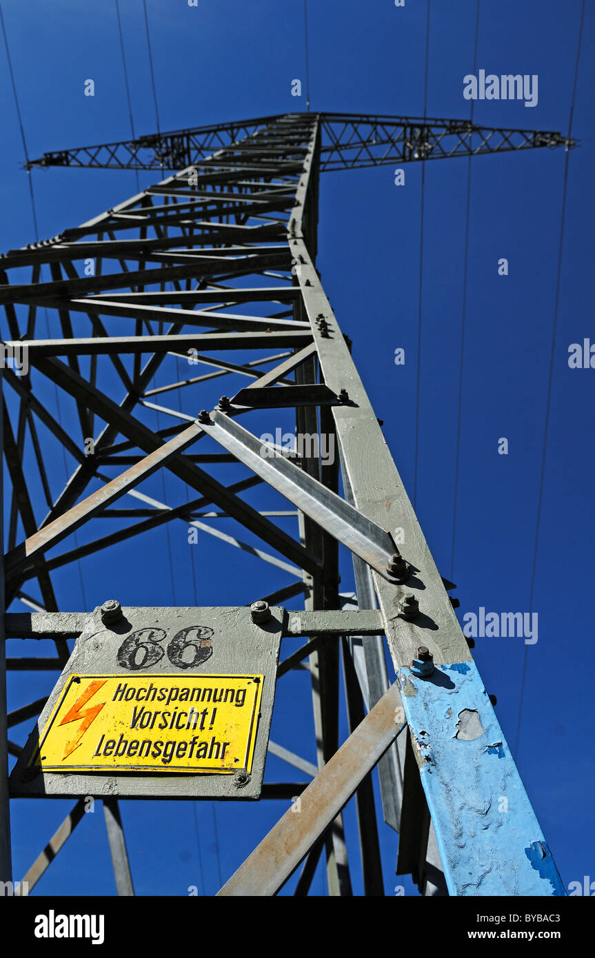 Sign, lettering 'Hochspannung Vorsicht! Lebensgefahr', German for 'Caution high voltage! Danger!' on an electricity pylon Stock Photo