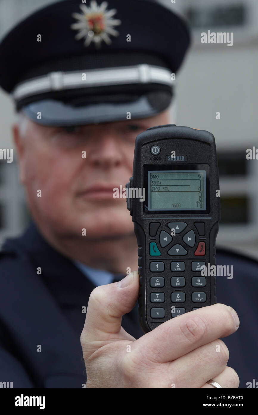 Police officer displaying a new digital radio which is currently being tested by the Rhineland-Palatinate police, Koblenz Stock Photo