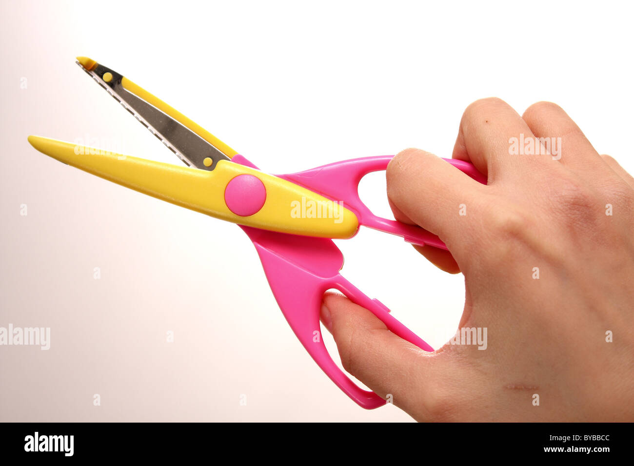 A white Caucasian female holding a pair of pink and yellow pinking