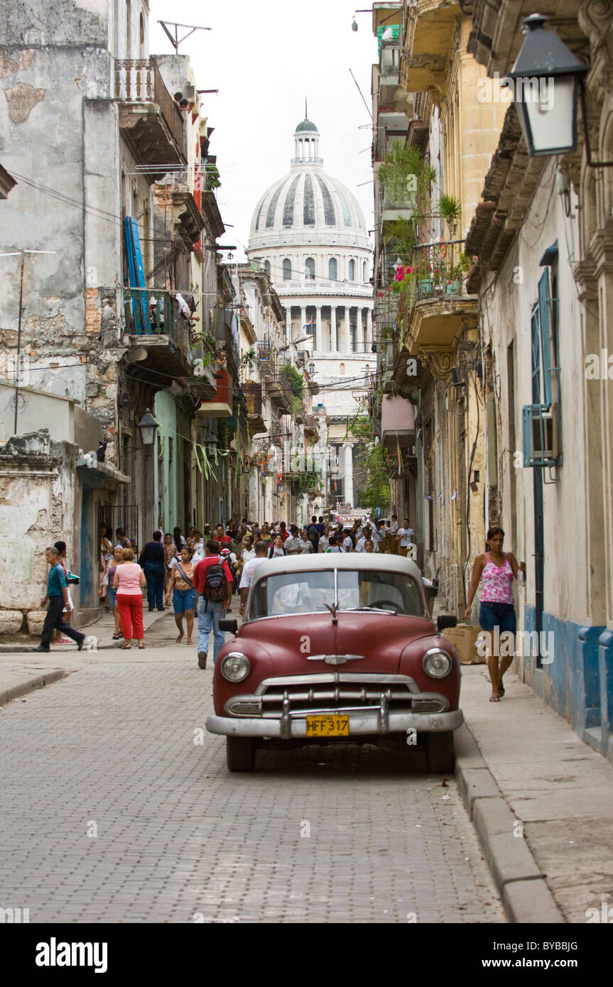 A typical narrow street in old town Havana Cuba with people and American car Stock Photo