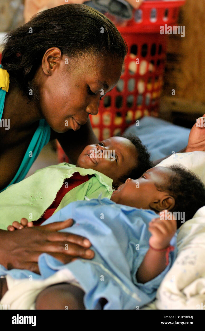 31-year-old mother Rosita Thomas with her twins Mickenson and Tickenson, 3 months, in an earthquake-proof prefabricated house Stock Photo