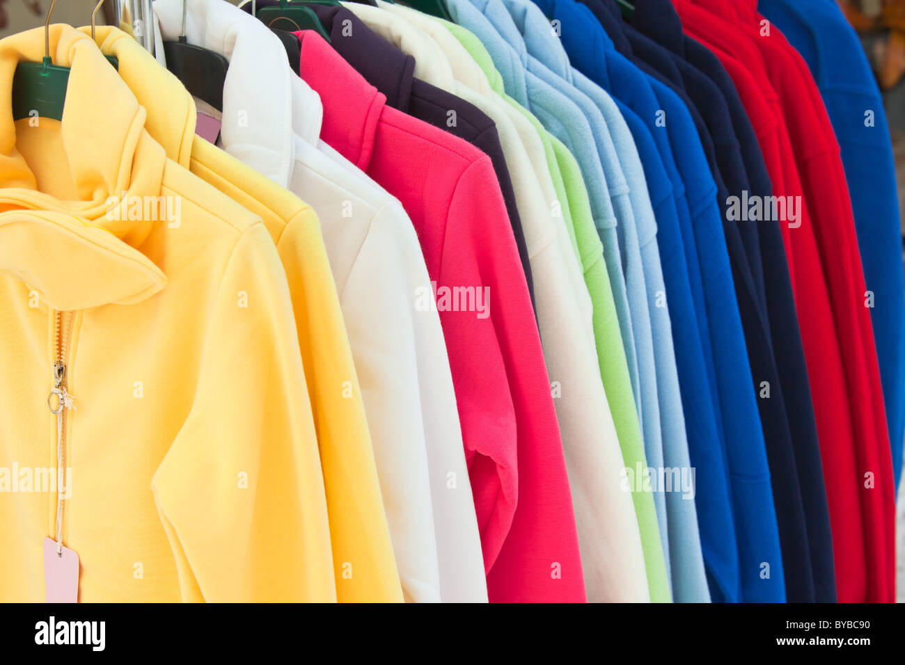 Colourful Textile sport shirts hanging in row at store Stock Photo