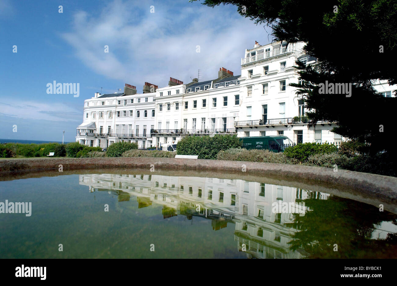 Classic Regency houses by the sea in Sussex Square, Brighton reflected in a bird bath in the communal gardens. Stock Photo