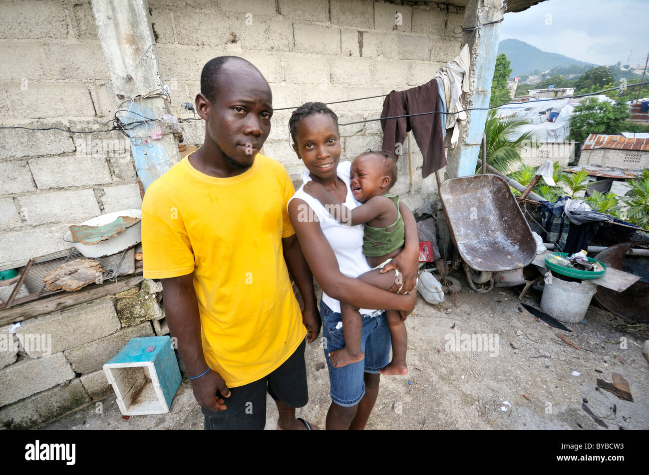Family, parents holding a baby, in front of their house, Delmas 89 district, Port-au-Prince, Haiti, Caribbean, Central America Stock Photo