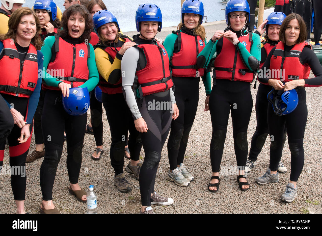 Group of women wearing wetsuits and lifejackets before going white