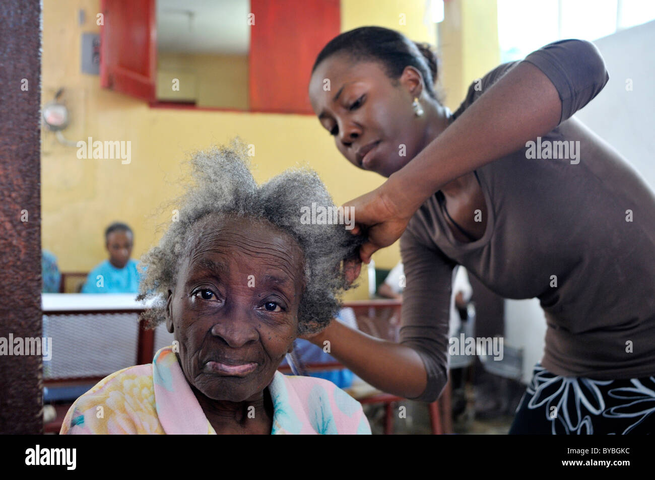 Volunteer hairdressing a senior citizen in a nursing home, Turgeau district, Port-au-Prince, Haiti, Caribbean, Central America Stock Photo